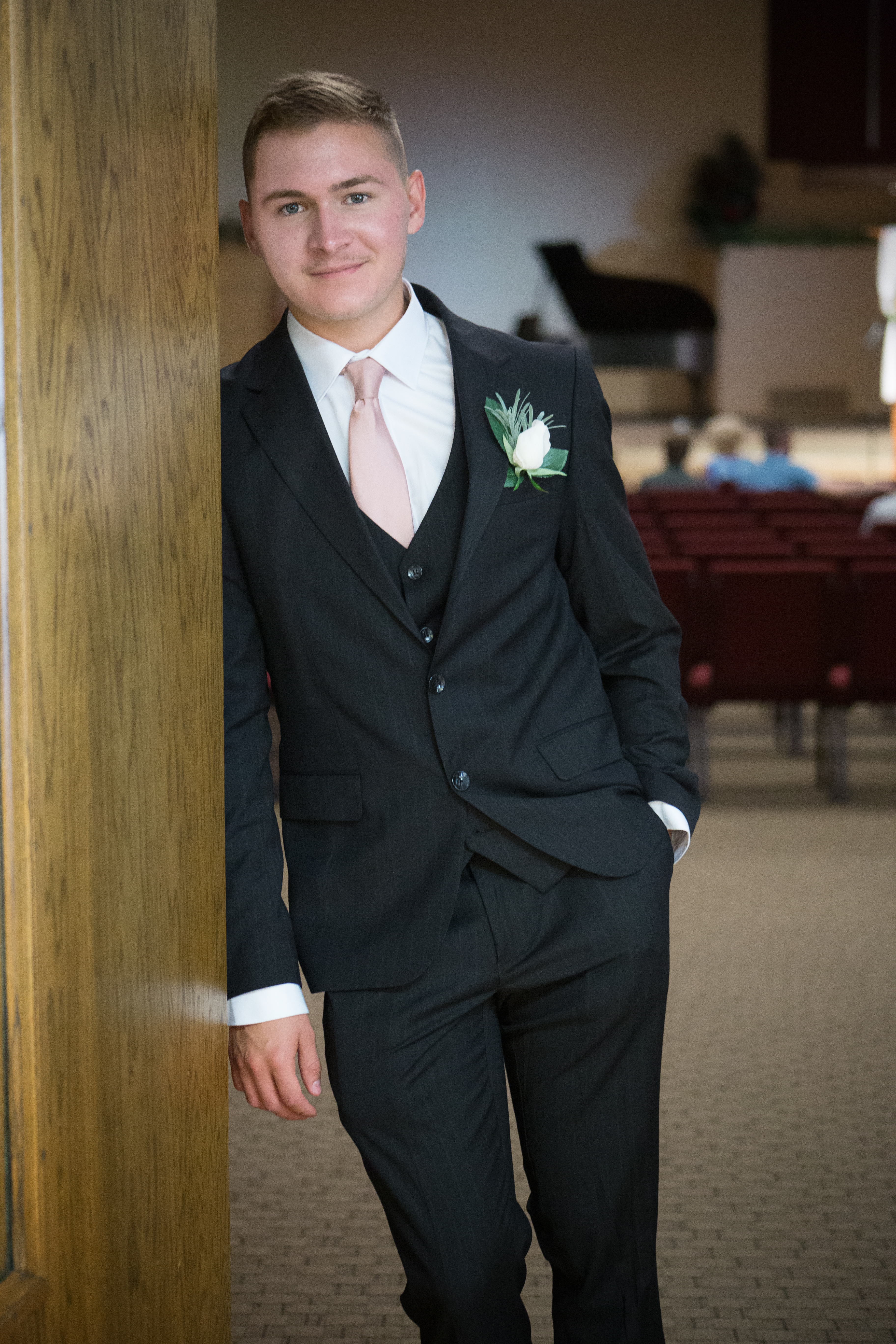 Ryan Meyer, founder of Prothie, standing beside a wooden pillar in a suit